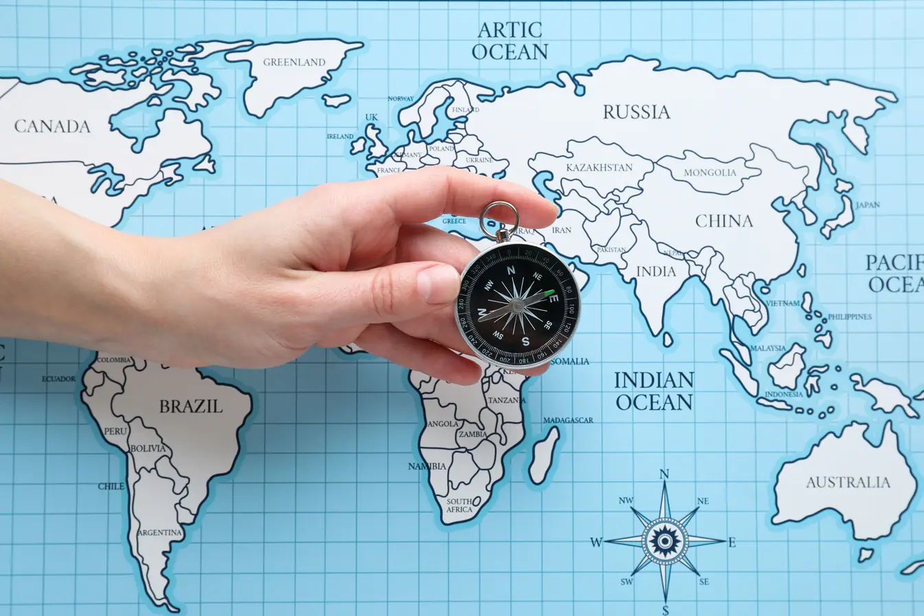 Assurance voyage internationale Main tenant une boussole sur une carte du monde